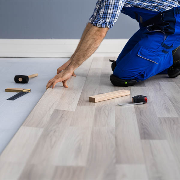 Photo of a man installing wood flooring.